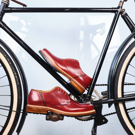 Rote Schuhe auf einem Fahrradpedal, stilvoll und einzigartig inszeniert.